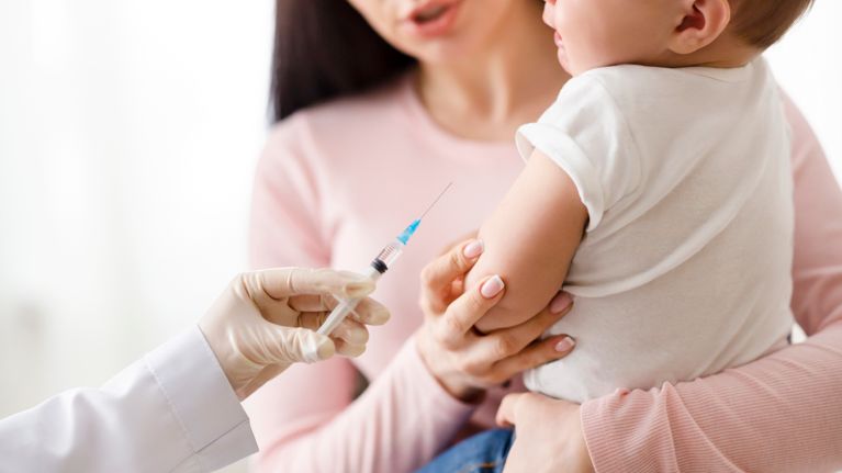 Doctor giving intramuscular injection to little baby