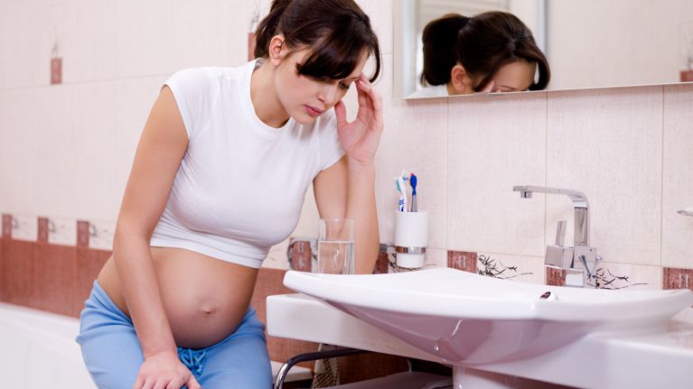 pregnant woman in the bathroom feeling dizzy