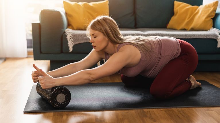 Pregnant Woman Doing Workout With Foam Roller At Home