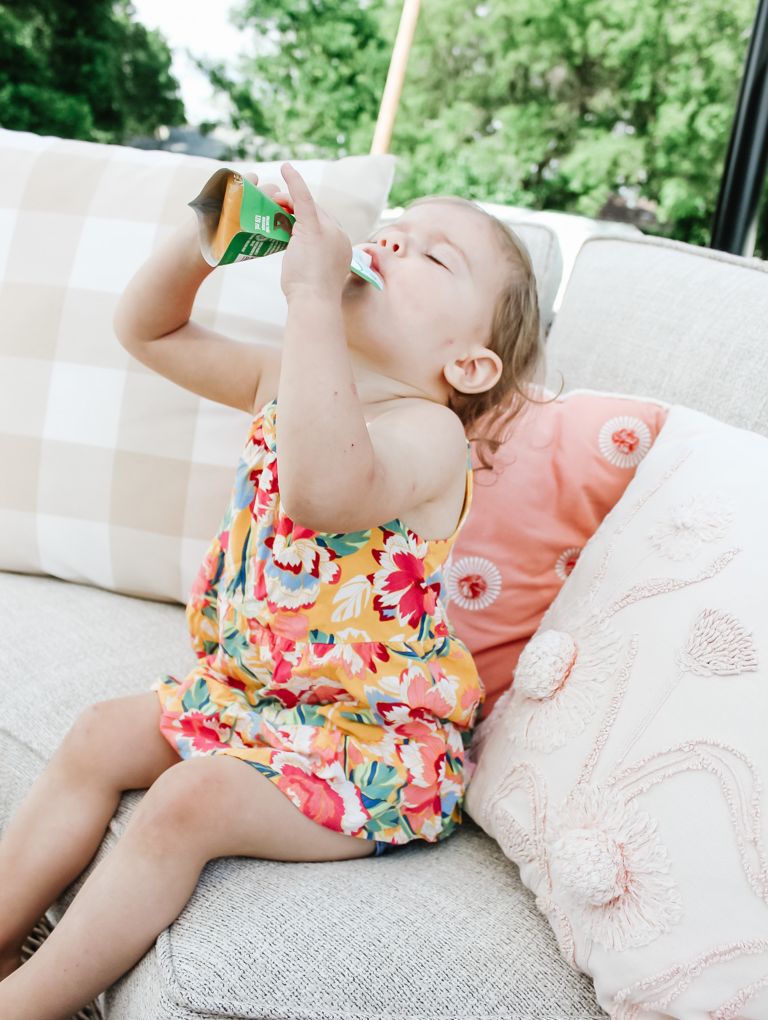 Toddler squeezing a puree pouch into her mouth