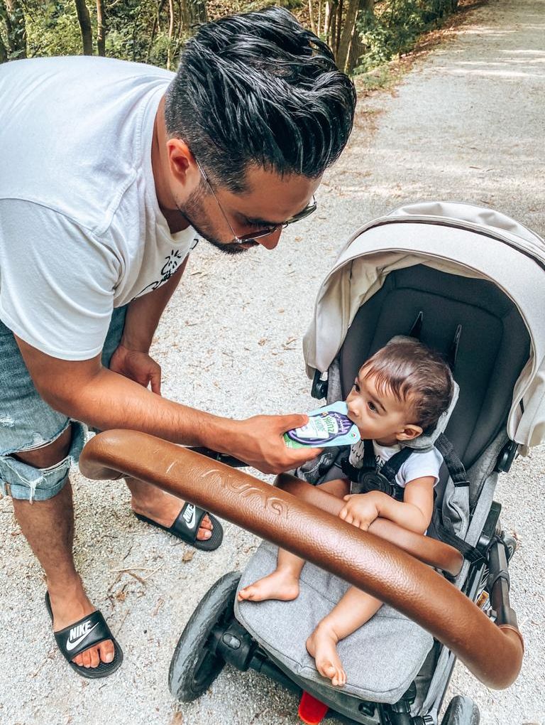 Dad feeding baby in stroller