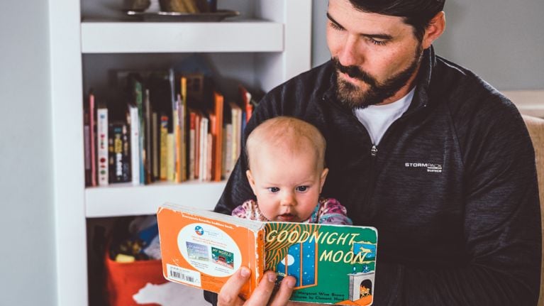 David Baque reading Goodnight Moon to his daughter as part of their steady patterns and routines for bedtime