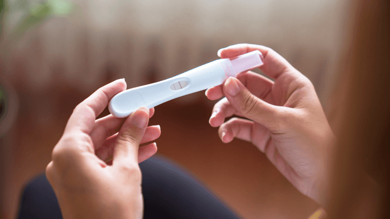 two hands holding a pregnancy test