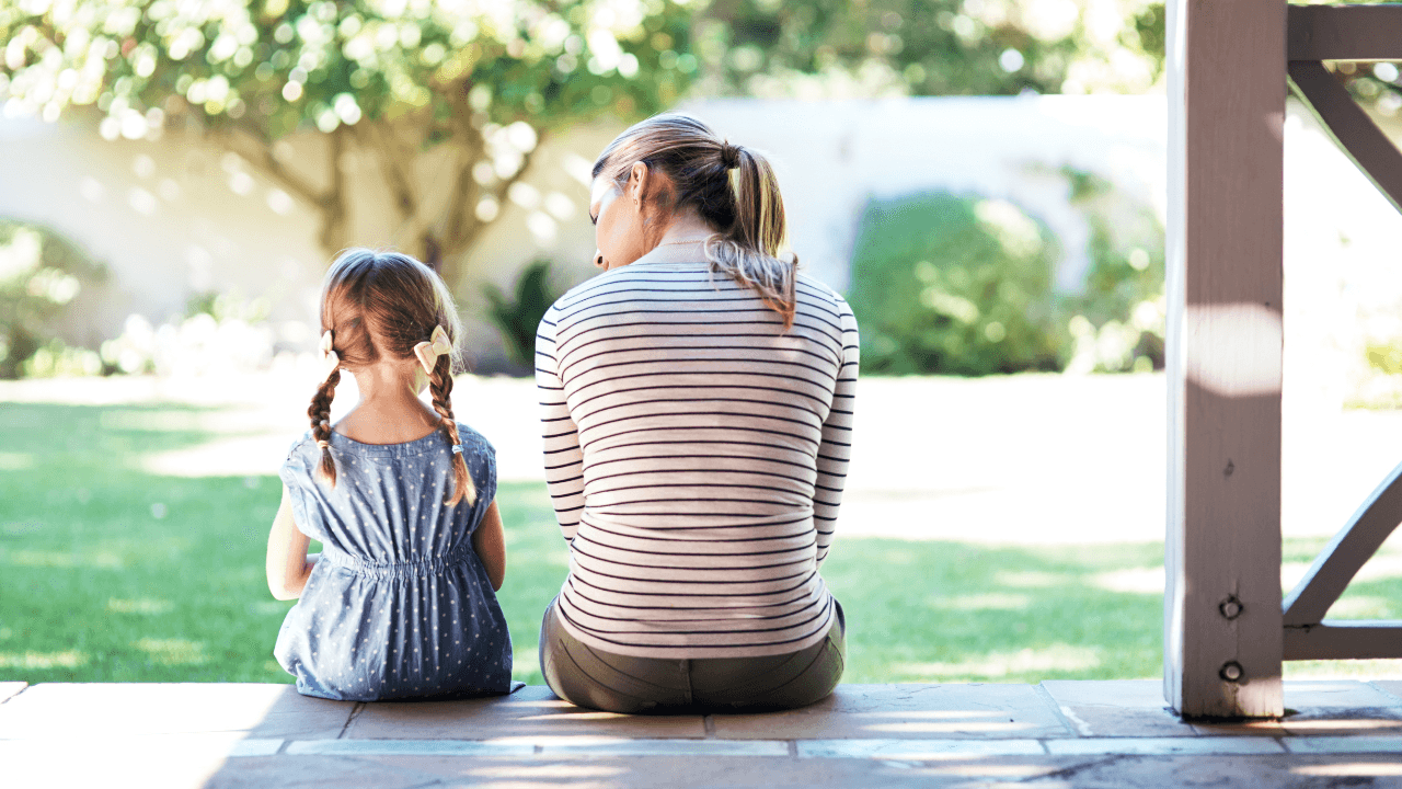 mom and daughter sitting on a porch looking out